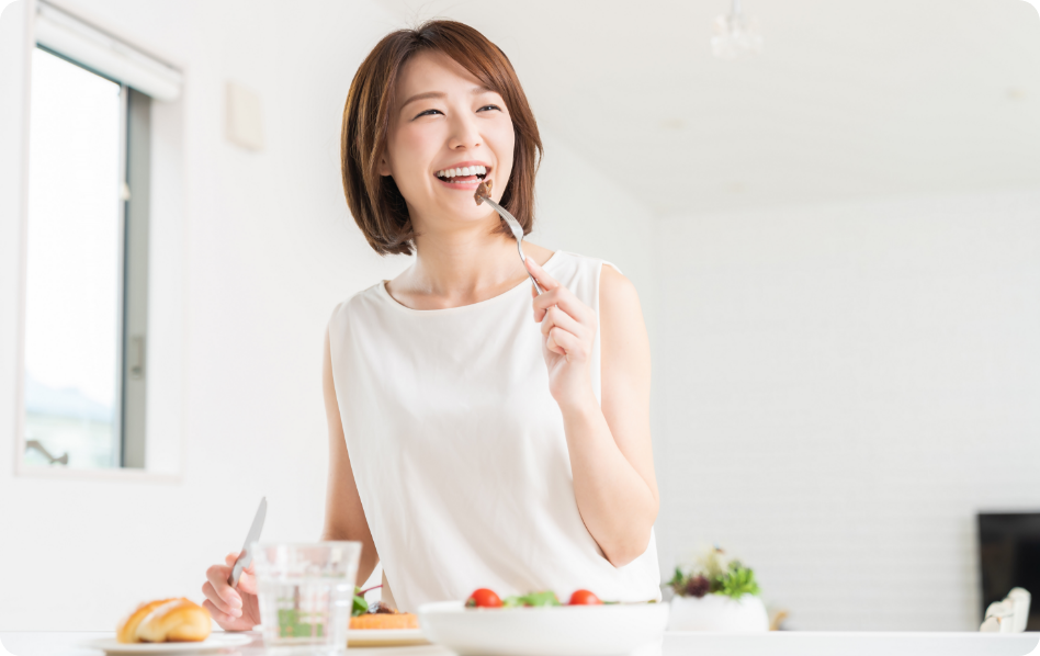 白く明るい部屋で朝食を食べる女性